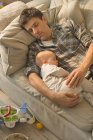 Виснажений батько і дитина син спить на дивані — стокове фото