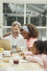 Multi-ethnic young family online shopping with credit card at laptop — Stock Photo