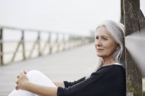 Pensiva donna anziana rilassante sul lungomare — Foto stock