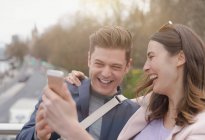 Смеющаяся пара делает селфи с камерой телефона — стоковое фото