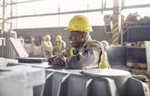 Lächelnder Stahlarbeiter schaut im Stahlwerk weg — Stockfoto