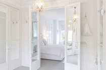 Білий, розкіш додому Вітрина інтер'єр спальної кімнати з французьких дверей і люстра — стокове фото