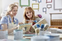 Artistas femeninas pintando marcos en taller de clase de arte - foto de stock