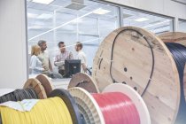 Supervisors talking in office behind spools in fiber optics factory — Stock Photo