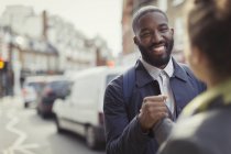 Усміхнений бізнесмен тремтить руками з колегою по міській вулиці — стокове фото