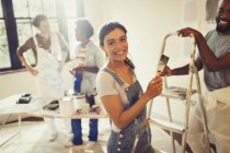 Portrait smiling, confident woman painting living room with friends — Stock Photo