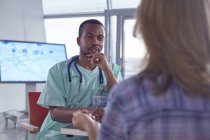 Male surgeon talking to female patient in hospital — Stock Photo