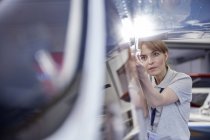 Focused ingegnere meccanico femminile esaminando aeroplano — Foto stock