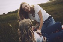 Playful teenage sisters in rural field — Stock Photo