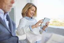 Seniorin nutzt digitales Tablet auf Terrasse — Stockfoto