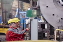 Trabalhadores do sexo masculino que operam máquinas no painel de controle na fábrica — Fotografia de Stock