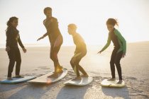 Family surfers practicing on surfboards on sunny summer beach — Stock Photo