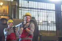 Male workers carrying steel part in factory — Stock Photo