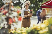 Sorridente fiorista femminile che lavora al negozio di fiori — Foto stock