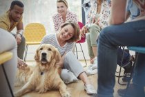Frau streichelt Hund in Gruppentherapie — Stockfoto
