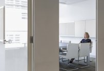 Ritratto donna d'affari in attesa in sala conferenze in ufficio moderno — Foto stock
