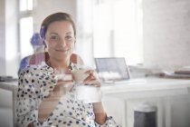 Ritratto donna d'affari sorridente che beve caffè in ufficio — Foto stock