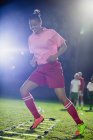 Jovens jogadoras de futebol praticando exercícios esportivos de agilidade em campo à noite — Fotografia de Stock