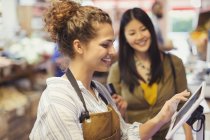 Cajero femenino ayudando al cliente en la caja registradora de pantalla táctil en la tienda de comestibles - foto de stock