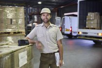 Portrait confident truck driver worker at distribution warehouse loading dock — Stock Photo