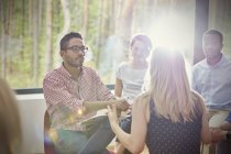 Attentive man listening to woman in group therapy session — Stock Photo