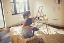 Junges Paar sieht sich Farbmuster an, bemalt Wohnzimmer — Stockfoto