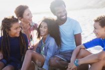 Багатоетнічна сім'я сміється на сонячному літньому пляжі — стокове фото