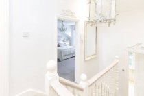 Blanco, hogar escaparate escalera de lujo aterrizaje con vista al dormitorio - foto de stock