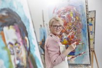 Портрет усміхненої жінки-художниці живопис на полотні в студії арт-класу — стокове фото