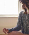 Спокойная женщина медитирует в позе лотоса с рукой в мудре Гьяна — стоковое фото
