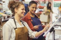 Caixa feminina ajudando a mulher grávida a pagar com cartão de crédito no supermercado caixa registradora — Fotografia de Stock