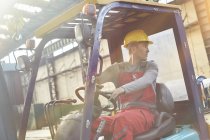 Arbeiter fährt Gabelstapler und sichert sich in Fabrik ab — Stockfoto