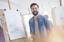 Portrait smiling male artist with beard sketching in art class studio — Stock Photo