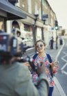 Enthousiaste jeune femme posant pour caméra vidéo sur la rue urbaine — Photo de stock