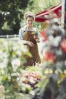Портрет усміхненої жінки-флориста, що тримає горщики на квітковому магазині — стокове фото