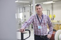 Trabajador masculino confiado en retratos en fábrica de fibra óptica - foto de stock