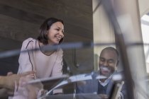 Усміхнений бізнесмен і бізнес-леді говорять на зустрічі — стокове фото