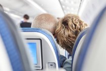 Rear view affectionate mature couple leaning on airplane — Stock Photo