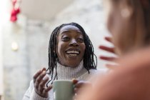 Femme enthousiaste buvant du café, parlant avec un ami — Photo de stock