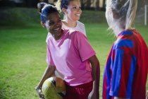 Juguetón, riendo joven fútbol femenino juega en el campo por la noche - foto de stock