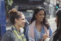 Lächelnde Freundinnen reden auf urbaner Straße — Stockfoto