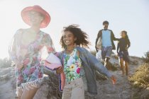 Smiling family walking on sunny summer beach hill — Stock Photo