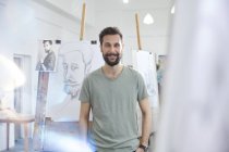 Portrait smiling, confident male artist sketching in art class studio — Stock Photo