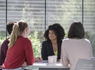 Mujeres de negocios hablando, planeando en la mesa en la reunión - foto de stock