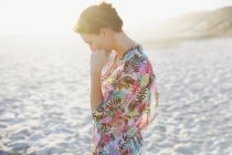 Serena donna bruna in costume da bagno copertura sulla spiaggia estiva soleggiata — Foto stock