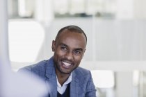 Lächelnder, begeisterter Geschäftsmann hört bei Treffen zu — Stockfoto