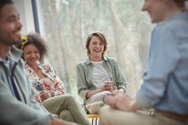 People smiling and laughing in group therapy session — Stock Photo