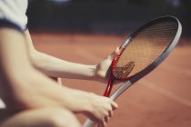 Jeune joueur de tennis masculin tenant une raquette de tennis — Photo de stock