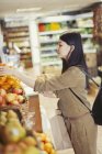 Молодая женщина покупает продукты в продуктовом магазине — стоковое фото