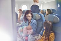 Мати тримає дитину на літаку — стокове фото